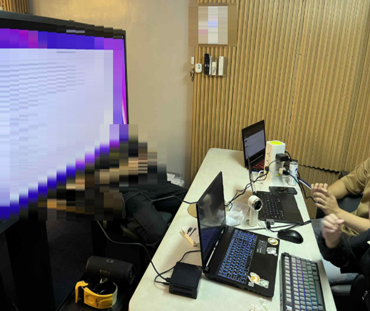 The team configuring the server and network devices on site, with laptops and a monitor set up in a working area. Faces and the screen contents are masked.
